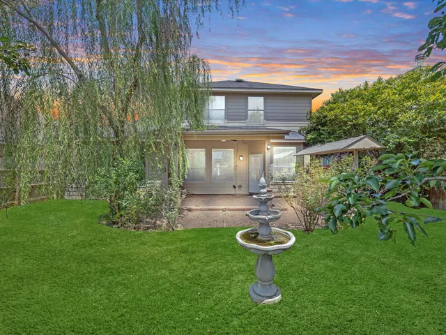 a view of a backyard with table and chairs and potted plants