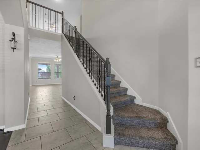 a view of staircase with white walls and railing