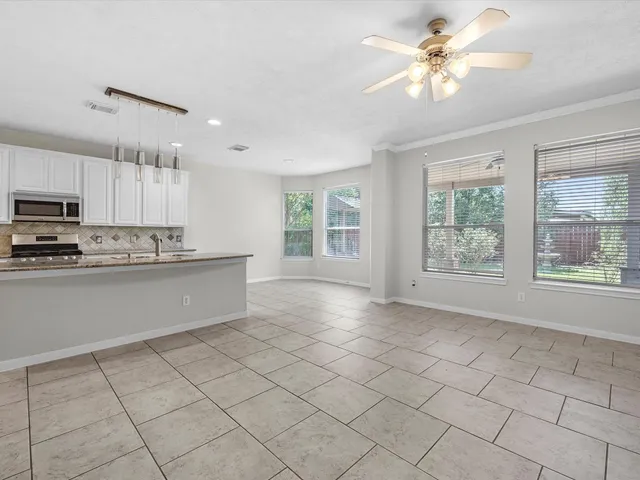 a large kitchen with stainless steel appliances granite countertop a stove a sink and a refrigerator