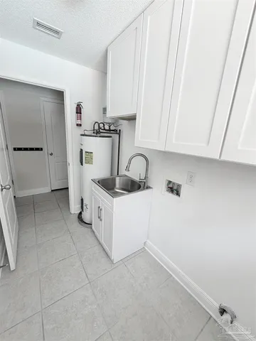 a kitchen with a sink a stove and cabinets
