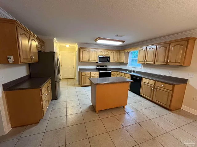 a kitchen with stainless steel appliances granite countertop a stove top oven a sink a counter top space and cabinets