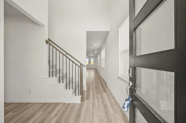 a view of a hallway with wooden floor and staircase