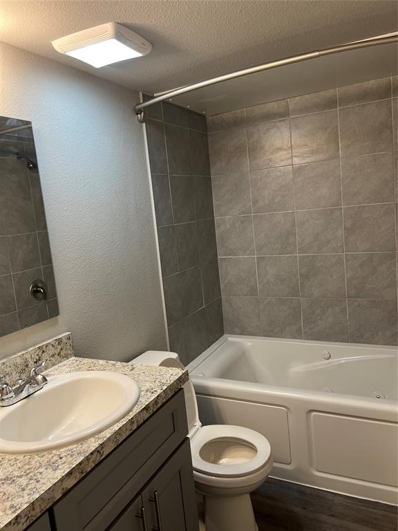 6108 Abrams Road, Unit 225 Dallas, TX 75231 - Photo 8 of 15 a bathroom with a granite countertop bathtub sink vanity mirror and toilet