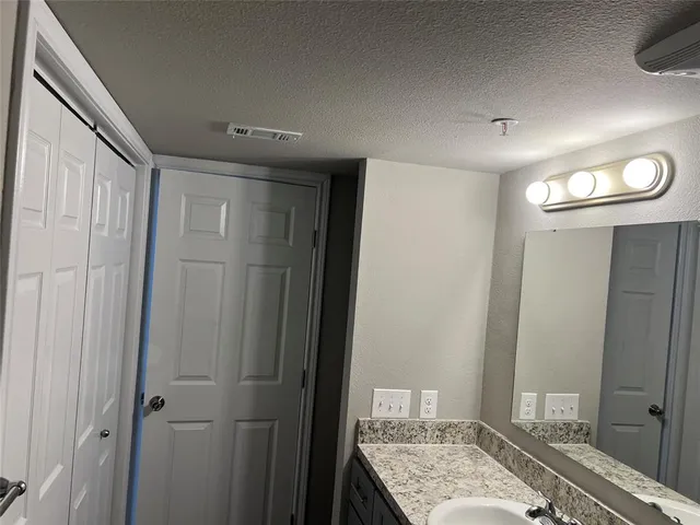 a bathroom with a granite countertop sink and a mirror