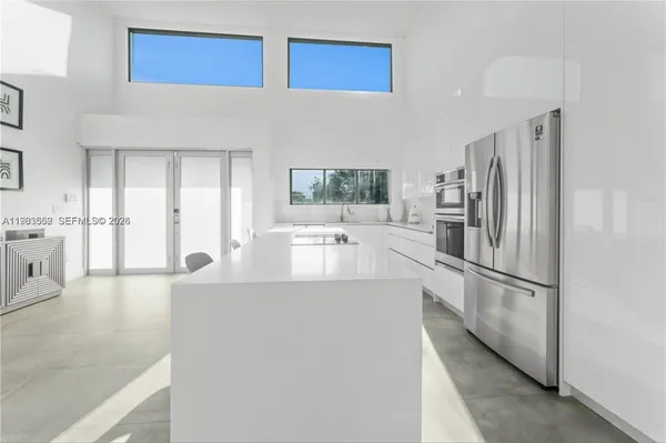 a kitchen with stainless steel appliances granite countertop a refrigerator and a sink
