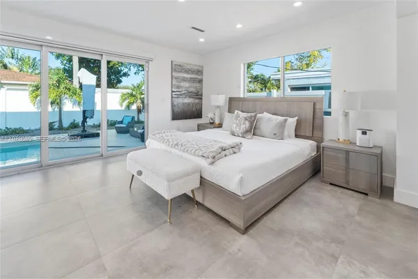 a bedroom with a bed and a large window