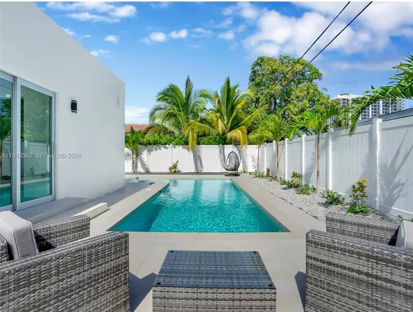a view of a backyard with potted plants and wooden fence