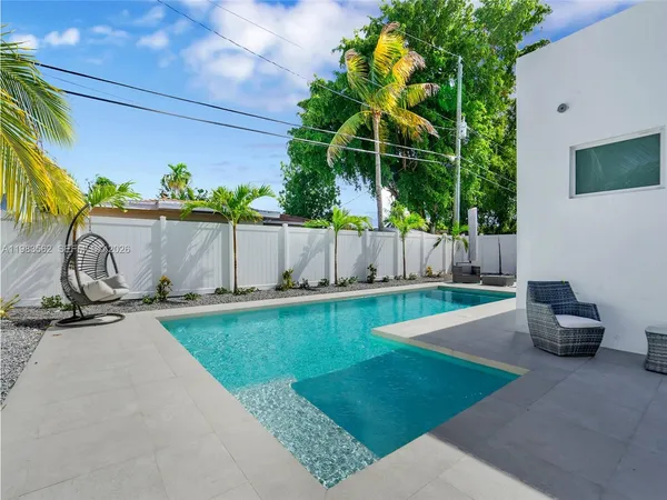 a living room with patio furniture and a potted plant