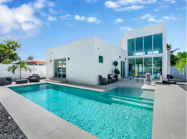 a living room with furniture and potted plants