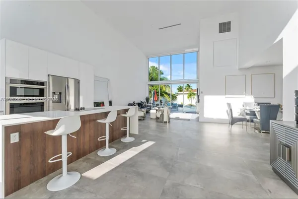 a large white kitchen with lots of counter space and windows