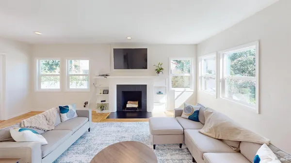 a living room with furniture a flat screen tv and a fireplace