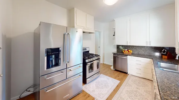 a kitchen with stainless steel appliances granite countertop a refrigerator and a stove