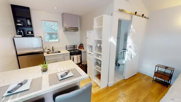 a kitchen with stainless steel appliances white cabinets and wooden floor