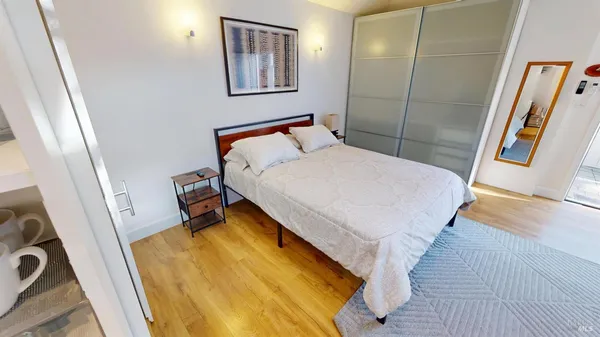 a bedroom with a bed and a mirror on the wall