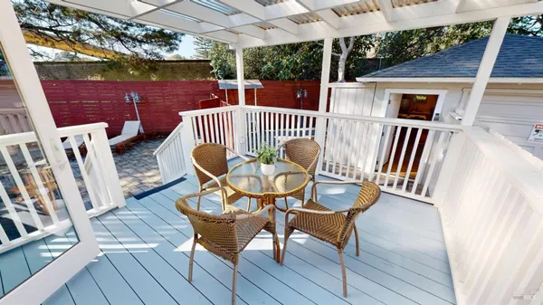 a view of a chairs and table in patio with wooden fence