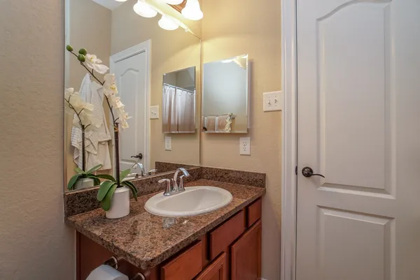 a bathroom with a granite countertop sink and a mirror