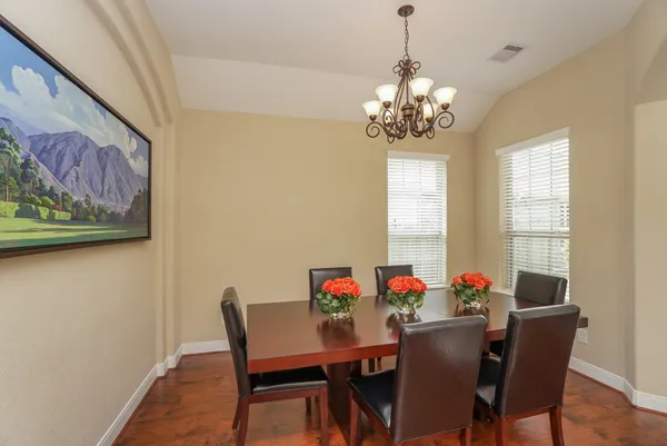 a view of a dining room with furniture a chandelier and wooden floor