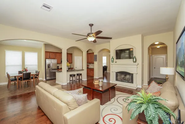 a living room with furniture a fireplace and a chandelier