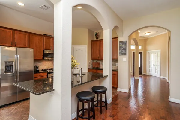 a kitchen with stainless steel appliances granite countertop a refrigerator and a stove top oven
