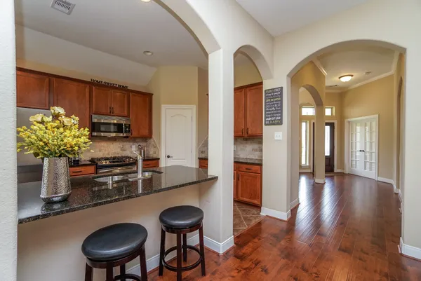 a kitchen with stainless steel appliances granite countertop a sink refrigerator and cabinets