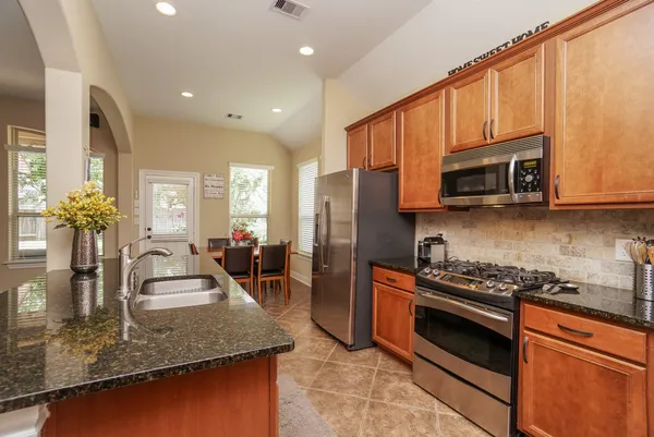 a kitchen with stainless steel appliances granite countertop a sink stove and microwave
