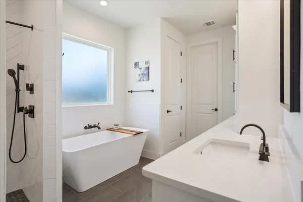 a spacious bedroom with a bed and a flat screen tv