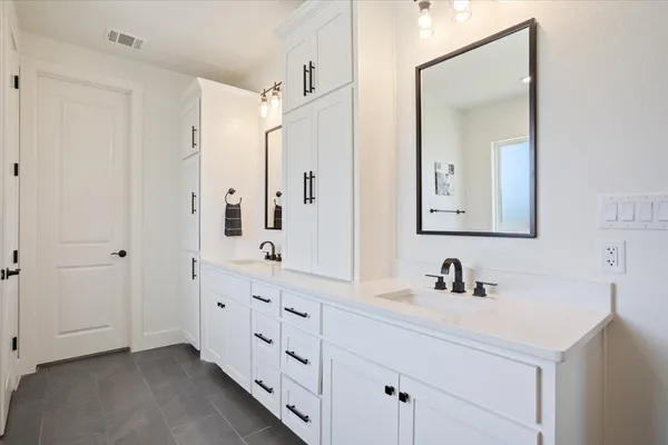 a spacious bathroom with a double vanity sink a mirror and a shower