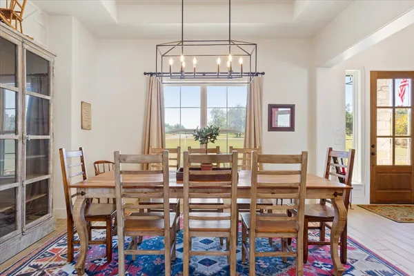 a view of a dining room with furniture a chandelier and wooden floor