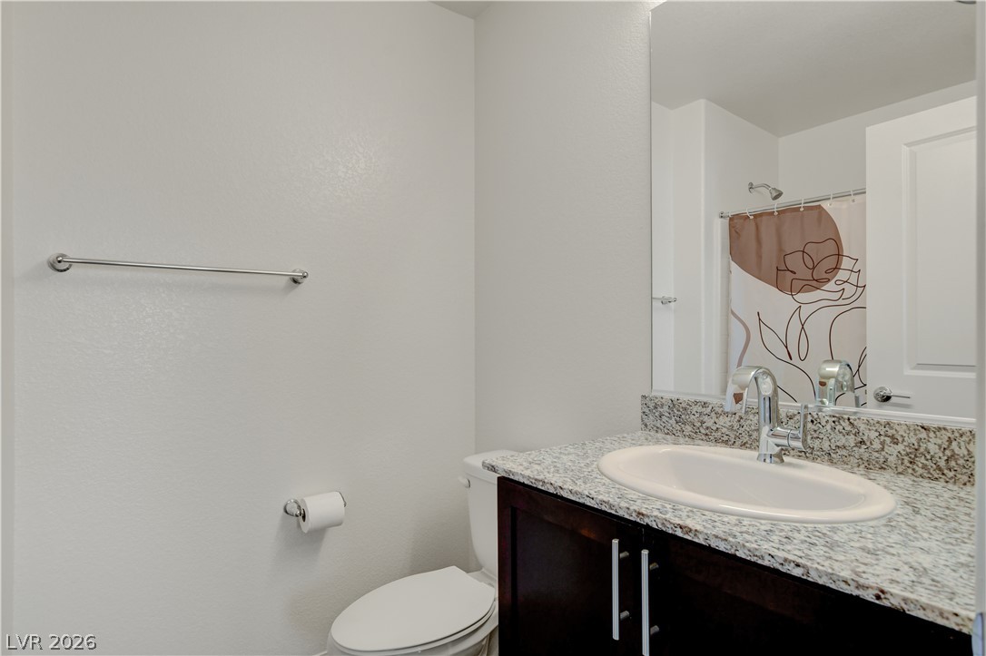 6924 Spicy Merlot Street North Las Vegas, NV 89086 - Photo 37 of 83 Granite counters and dark wood cabinetry define this well-appointed bathroom.