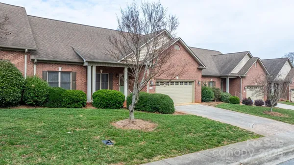 a view of a white house with a yard and plants