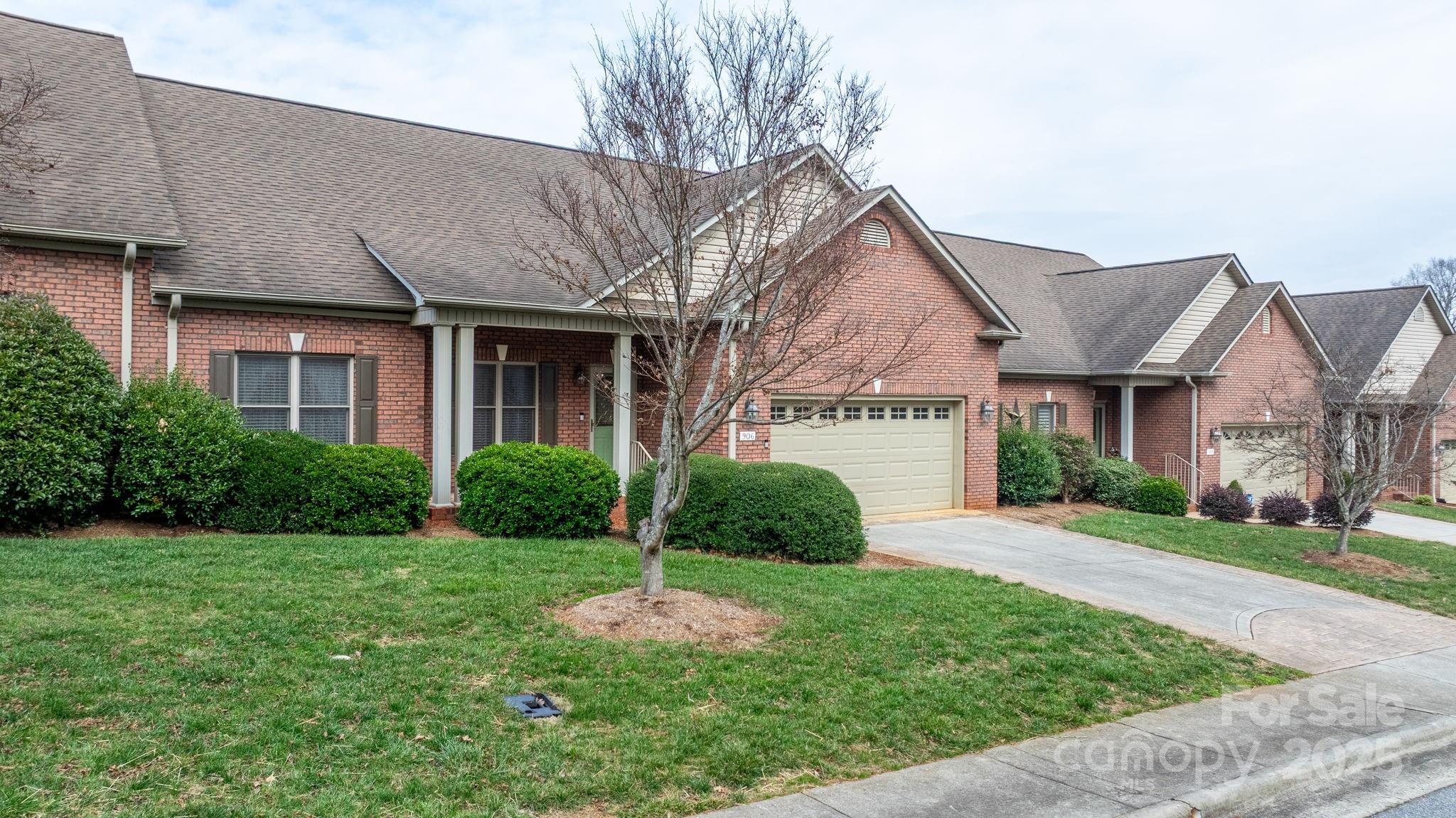 a view of a white house with a yard and plants