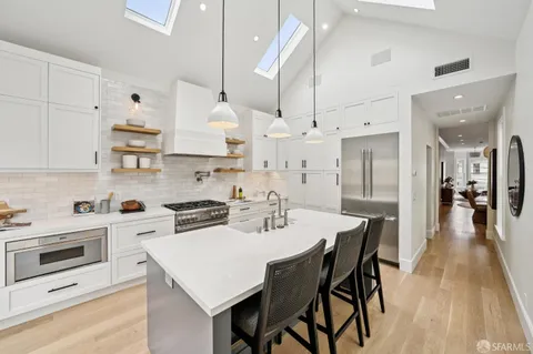 a kitchen with stainless steel appliances granite countertop a sink wooden cabinets and a refrigerator