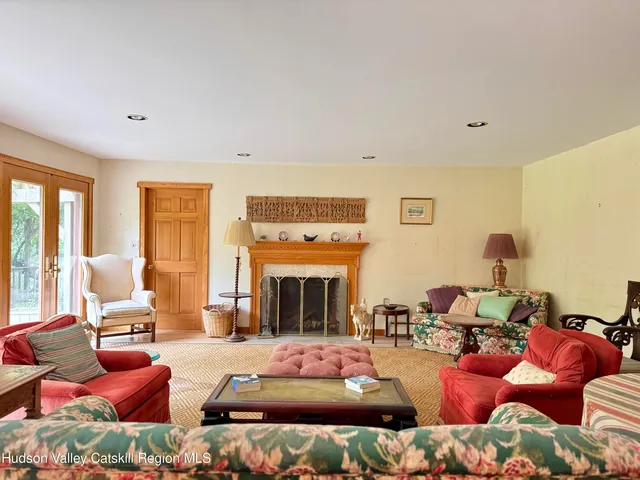 a living room with furniture fireplace and a large window