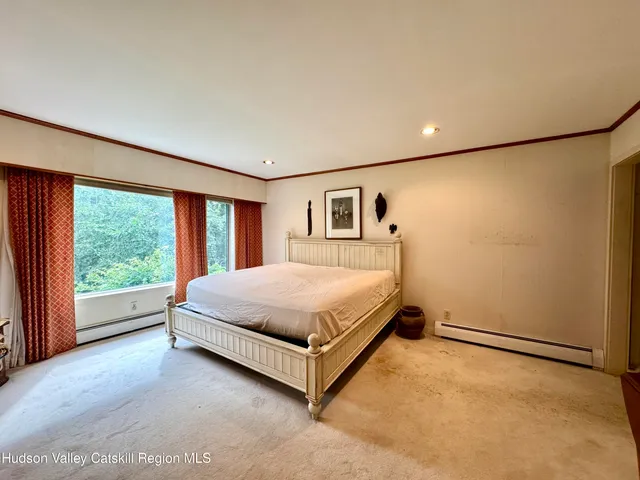 a bed sitting in a spacious bedroom next to a window