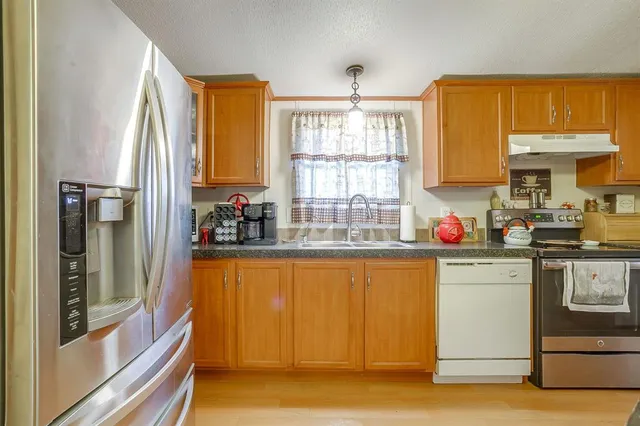a kitchen with a refrigerator a stove and a sink