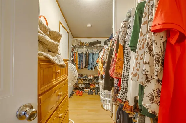a view of walk in closet with clothes