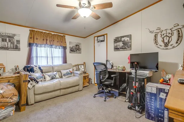 a living room with furniture a flat screen tv and a window