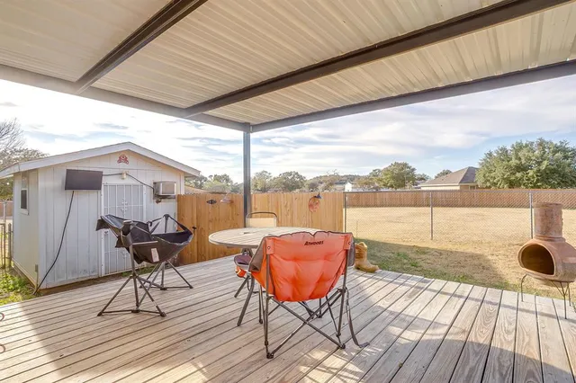 a balcony with wooden floor and outdoor seating