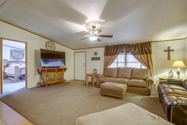 a living room with furniture a flat screen tv and a chandelier