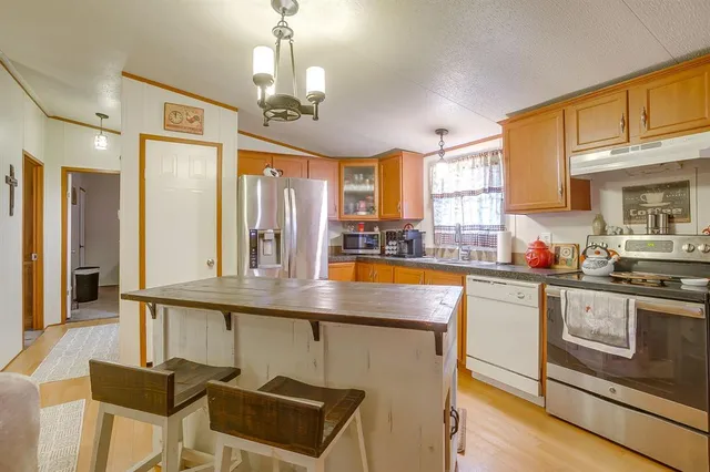 a kitchen with stainless steel appliances granite countertop a stove and cabinets