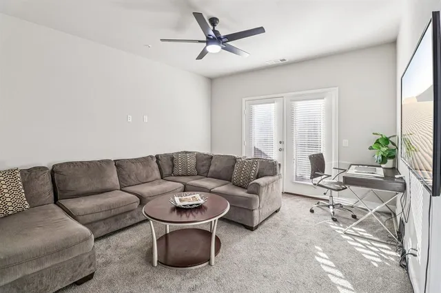 a living room with furniture a large window and a chandelier