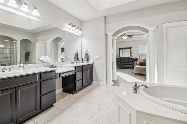 a spacious bathroom with a double vanity sink double mirror and bathtub