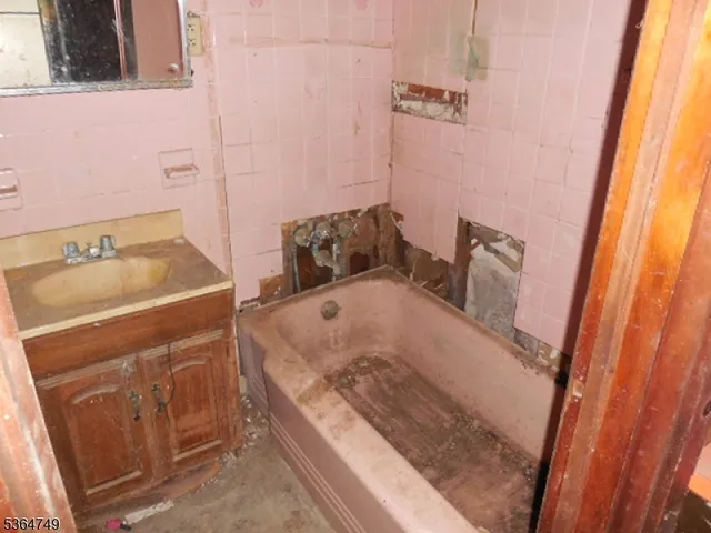 a bathroom with a tub sink and mirror