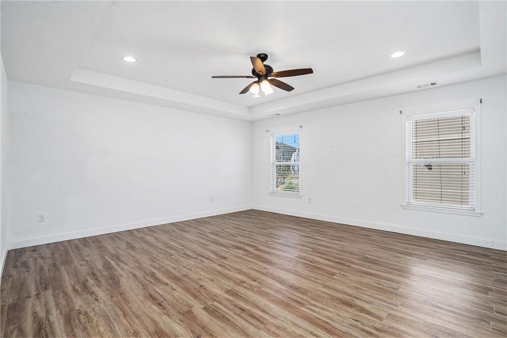 115 Floating Leaf Way Dallas, GA 30132 - Photo 17 of 47 an empty room with wooden floor ceiling fan and windows