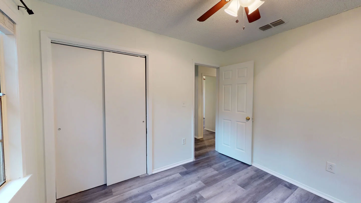 1109 Gardner Cove Austin, TX 78721 - Photo 10 of 13 A well-lit room featuring durable wood-like vinyl flooring and a convenient closet with bi-fold doors.