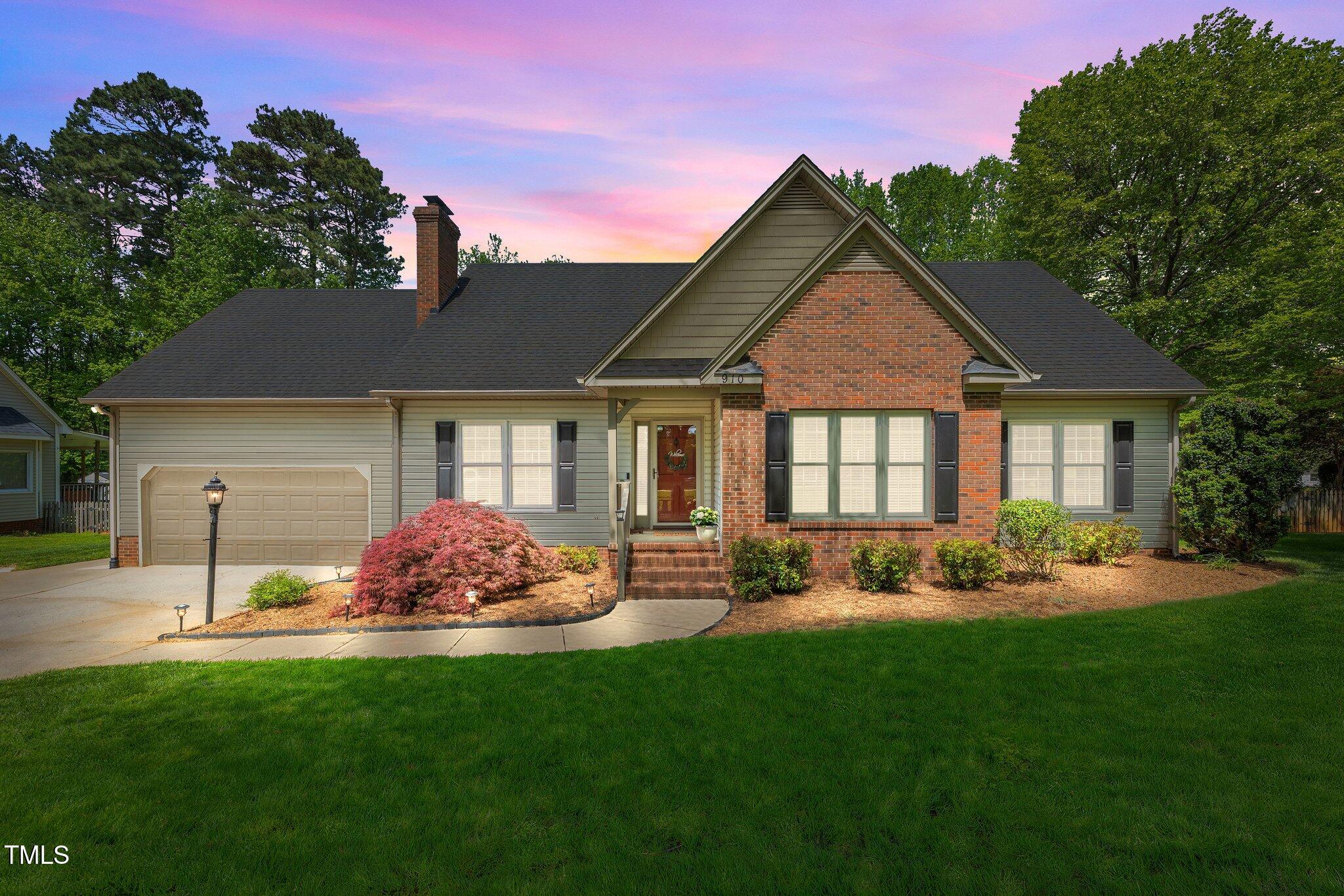 a front view of a house with a yard and green space