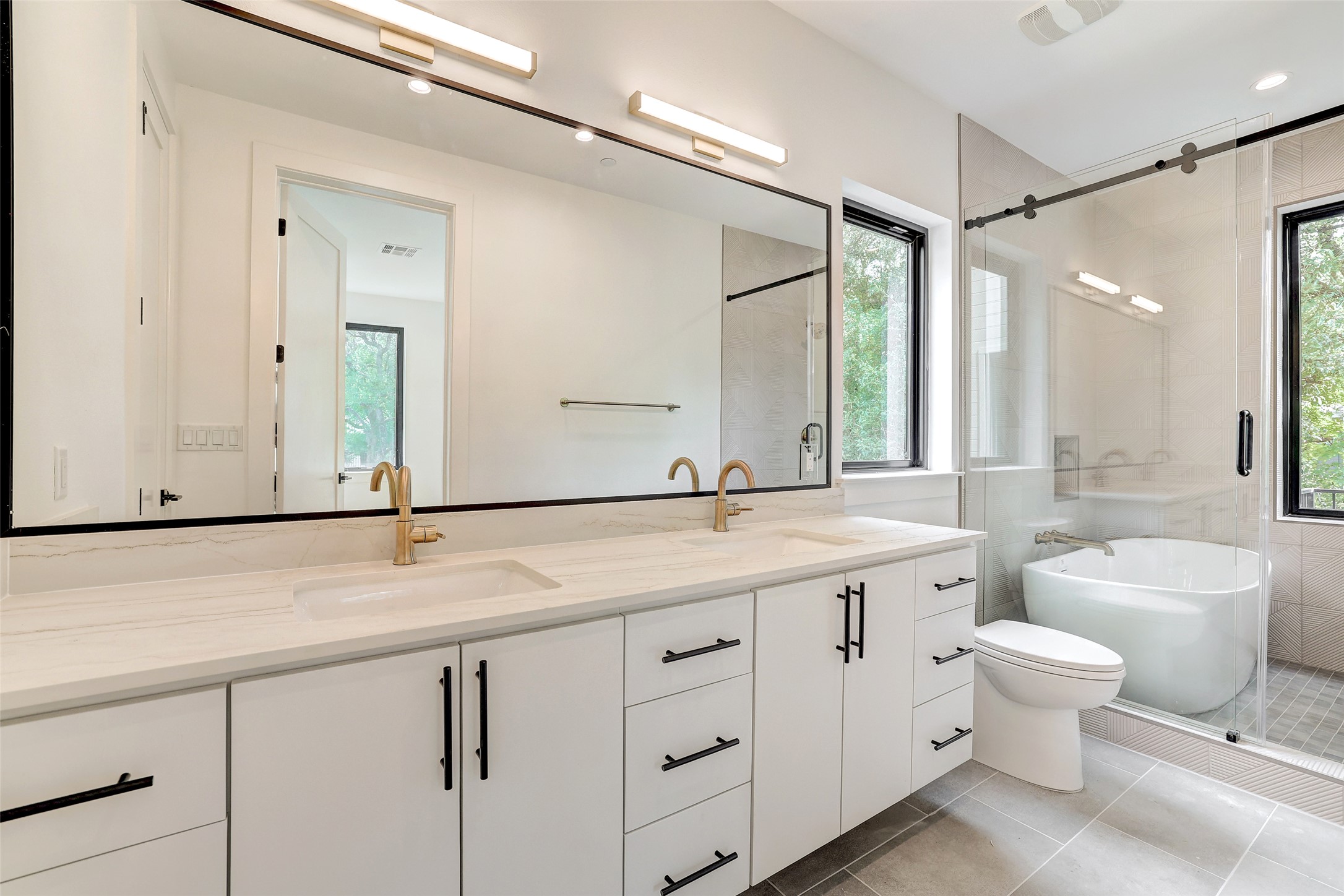 3208 Clawson Road, Unit 5A Austin, TX 78704 - Photo 16 of 34 Bathroom with double vanity, a freestanding bath, tile patterned floors, and a shower stall