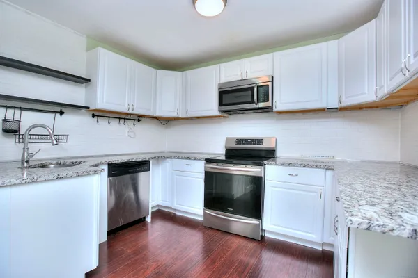 a kitchen with stainless steel appliances a refrigerator and a stove top oven