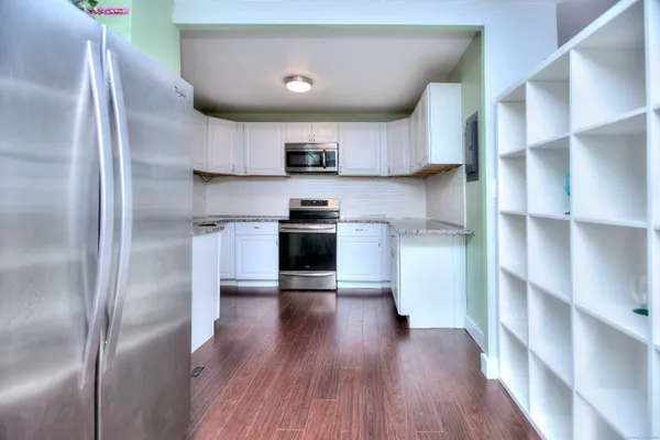 a kitchen with wooden floors and cabinets