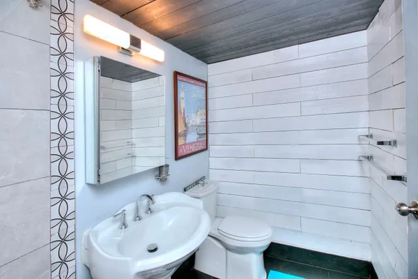 a bathroom with a sink shower and a mirror